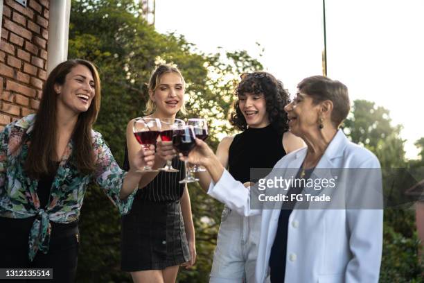 Family doing a celebratory toast with wineglass outdoors - including two female transsexual