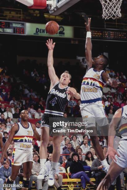 Scott Skiles, Point Guard for the Orlando Magic attempts a one handed lay up shot to the basket as Anthony Cook of the Denver Nuggets attempts to...