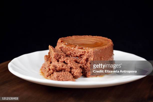 food for animals, canned pate on a white plate on a dark background - pate foto e immagini stock