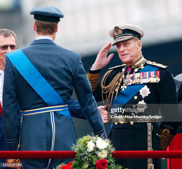 Prince Philip, Duke of Edinburgh salutes his grandson Prince William, Duke of Cambridge whilst onboard the Royal Barge 'Spirit of Chartwell' during...