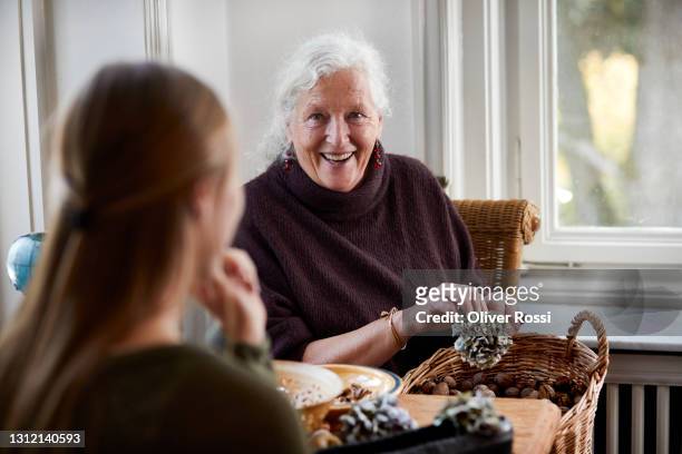 happy senior woman making flower arrangement at home - grandma cane stock pictures, royalty-free photos & images
