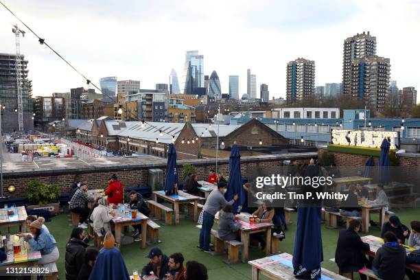 Members of the public gather for drinks at The Skylight roof top bar on April 12, 2021 in London, England. England has taken a significant step in...