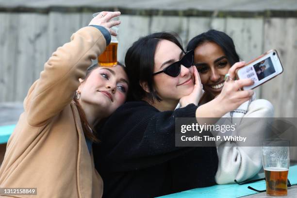 Girls raise a glass and take a selfie at The Skylight roof top bar on April 12, 2021 in London, England. England has taken a significant step in...