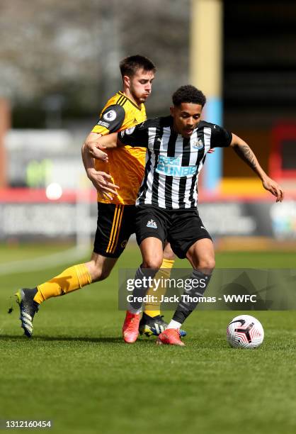 Christian Atsu of Newcastle United is challenged by Jack Scott of Wolverhampton Wanderers during the Premier League 2 match between Wolverhampton...