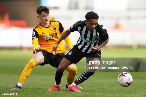 Christian Atsu of Newcastle United is challenged by Luke Cundle of Wolverhampton Wanderers during the Premier League 2 match between Wolverhampton...