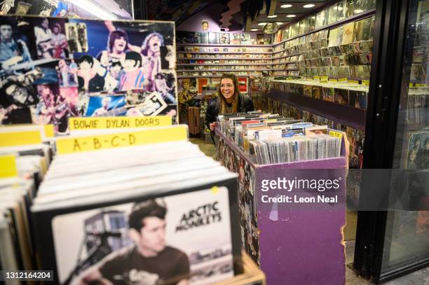 Woman moves a display of vinyl records outside the store as it re-opens in Camden Market, following the change in lockdown restrictions on April 12,...
