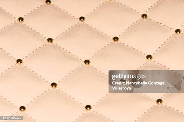 close up of light pink checkered faux leather with metallic studs - button sewing item stock-fotos und bilder