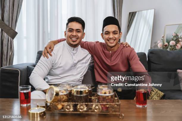 brotherhood. young men wearing malay traditional costume during hari raya celebration. - handsome muslim men stock pictures, royalty-free photos & images