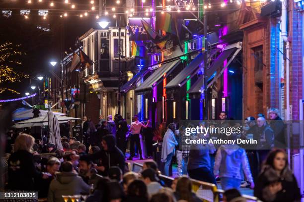 Patrons sit at tables outside bars on Canal Street on April 12, 2021 in Manchester, England. England has taken a significant step in easing its...