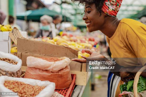 young african woman buying spices at the market - spice market stock pictures, royalty-free photos & images
