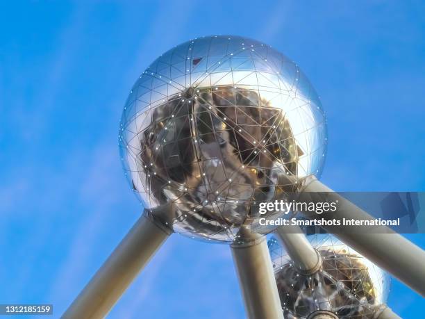 brussels atomium illuminated at late dusk with clear blue sky in brussels, belgium - atomium monument stock pictures, royalty-free photos & images