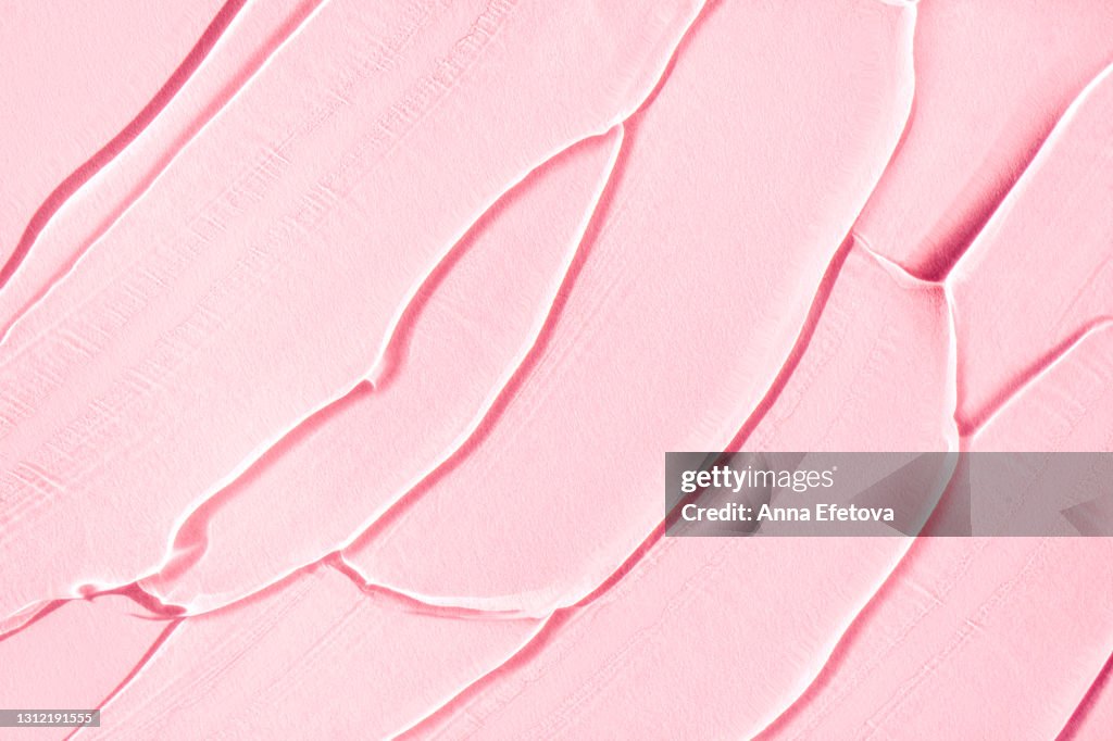 Smears of gel on pastel pink background. Modern abstract pattern. Flat lay style and close-up