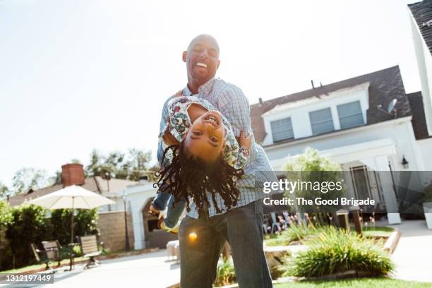 father and daughter having fun in backyard at home - family home exterior stock-fotos und bilder