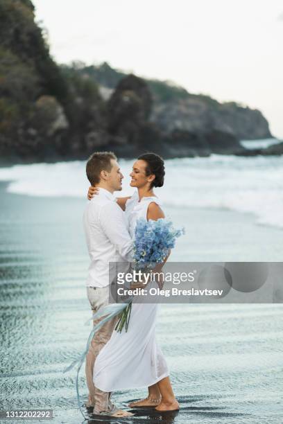 wedding couple enjoying on beach in bali. young and happy. tropical destination wedding - delphinium stock pictures, royalty-free photos & images