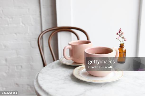 close-up of two pink coffee cups on marble cafe table in cafe - setting the table stock-fotos und bilder