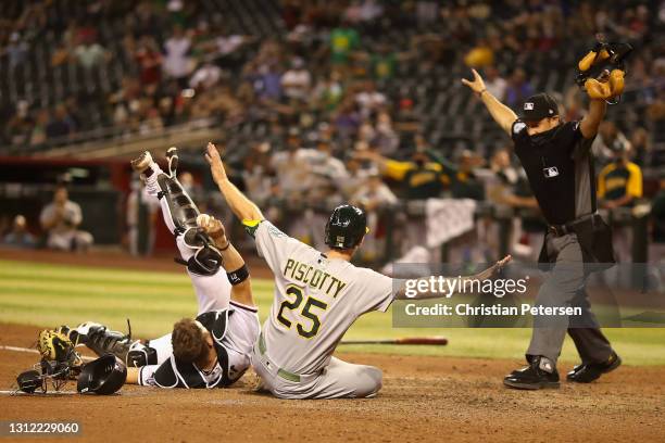 Stephen Piscotty of the Oakland Athletics safely scores a run ahead of the tag from catcher Stephen Vogt of the Arizona Diamondbacks during the...