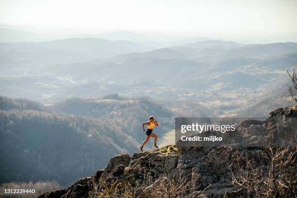 mujer corriendo en la montaña - action foto sport fotografías e imágenes de stock