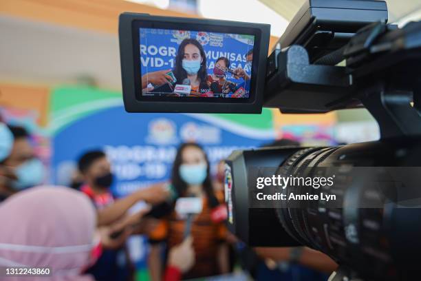 Malaysia Olympic artistic gymnast Farah Ann Abdul Hadi is seen through a video camera screen as she fields questions during a press conference after...