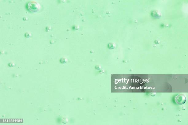 texture of organic transparent aloe vera gel or moisturizing lotion with many air bubbles on light green monochrome background. concept of healthy skin care with herbal cosmetic products. close-up and flat lay style with copy space - mint green photos et images de collection