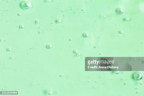 texture of organic transparent aloe vera gel or moisturizing lotion with many air bubbles on light green monochrome background. concept of healthy skin care with herbal cosmetic products. close-up and flat lay style with copy space - mint green stock pictures, royalty-free photos & images