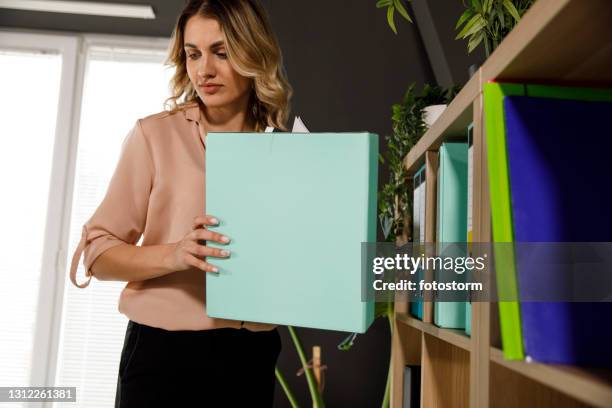 businesswoman organizing file binders on the shelf - binder shelves stock pictures, royalty-free photos & images