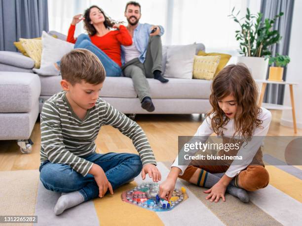 cheerful children playing board games. - ludo stock pictures, royalty-free photos & images