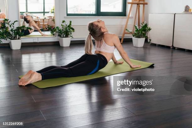 young pretty woman practicing yoga at home - coronavirus moldova stock pictures, royalty-free photos & images