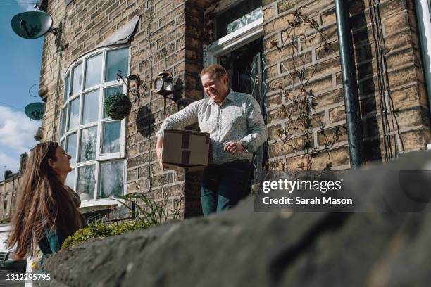 neighbour dropping off parcel - buren stockfoto's en -beelden