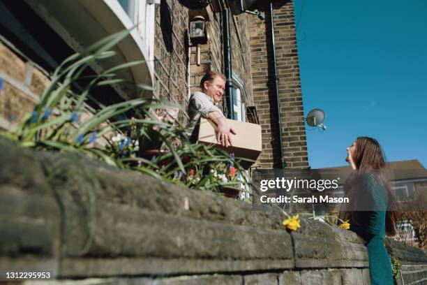 neighbour dropping off parcel - neighbours talking stock pictures, royalty-free photos & images