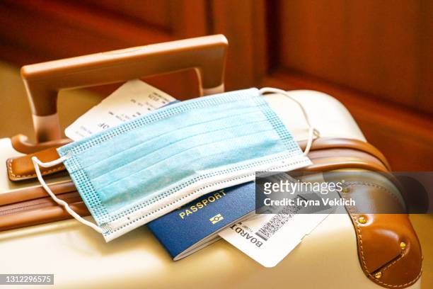 travel suitcase or luggage, passport, air ticket and facial mask during the pandemic of coronavirus or covid-19.. - epidemie stock-fotos und bilder