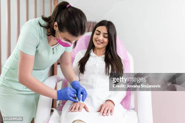 doctor giving an injection into her patients problem area - males imagens e fotografias de stock
