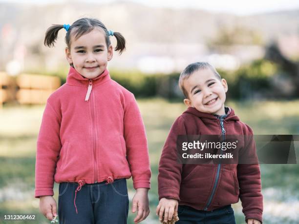 porträt von schönen kind mädchen und junge im freien in frühling saison - saison 2 stock-fotos und bilder