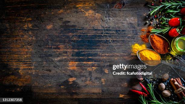farbige gewürze und kräuter säumen auf dunklem tisch - flat lay photography stock-fotos und bilder