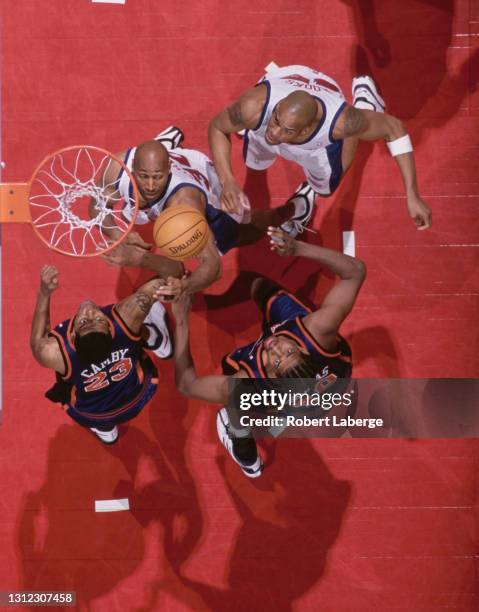 Marcus Camby and Kurt Thomas, Power Forward and Center for the New York Knicks challenge for the basketball beneath the hoop with Derek Strong and...