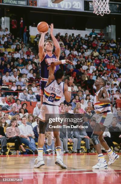 Tom Chambers, Power Forward for the Phoenix Suns attempts a three point jump shot to the basket over Alex English, small forward for the Denver...