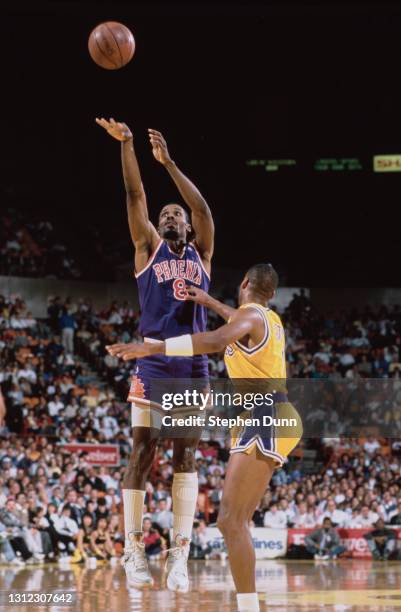 Eddie Johnson, Small Forward and Shooting Guard for the Phoenix Suns attempts a three point jump shot to the basket over Byron Scott of the Los...