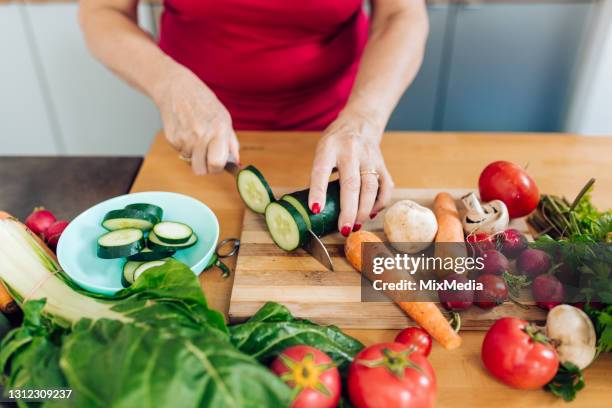 unrecognizable woman chopping veggies at her kitchen - chop stock pictures, royalty-free photos & images