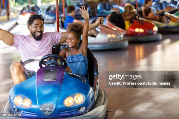 un padre feliz y una niña linda se están divirtiendo en el parque de entretenimiento. - parque de diversiones fotografías e imágenes de stock