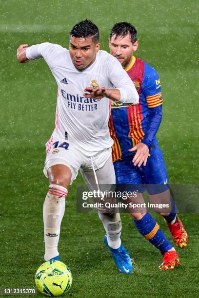 Casemiro of Real Madrid battle for the ball with Lionel Messi of FC Barcelona during the La Liga Santander match between Real Madrid and FC Barcelona...