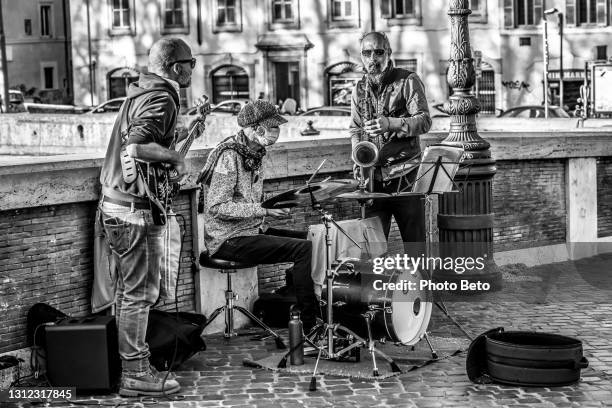 alguns músicos de rua toam ao longo da ponte sisto em trastevere na época de covid-19 - journey band members - fotografias e filmes do acervo