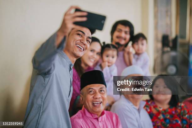 malaysische malay familie macht selfie-foto blick auf kamera winken zu hause feiern hari raya - hari raya celebration stock-fotos und bilder