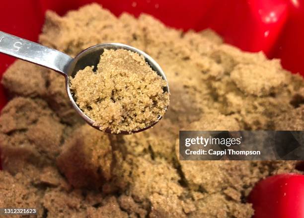 close up of some brown sugar in a measuring spoon - zucchero di canna foto e immagini stock