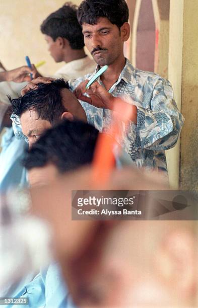 Barbers shave men''s heads June 3, 2001 in the Nepalese capital of Kathmandu as a sign of respect for their king and other members of the royal...