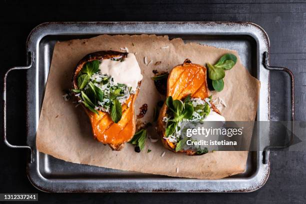 roasted butternut squash pumpkin with rice tabbouleh, lemon tahini dressing and fresh herbs - winter vegetables foto e immagini stock