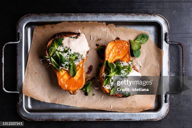 roasted butternut squash pumpkin with rice tabbouleh, lemon tahini dressing and fresh herbs - winter vegetables stockfoto's en -beelden