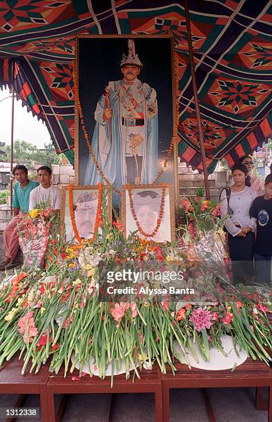 Mourners pass a shrine with a portrait of Nepalese King Birendra and a photograph of the King and Queen Aishwory June 2, 2001 in Kathmandu. The King...