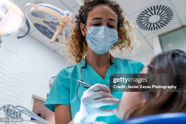 dentist woman examining little girl - zwei zahnärzte stock-fotos und bilder
