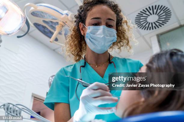 dentist woman examining little girl - tandarts stockfoto's en -beelden