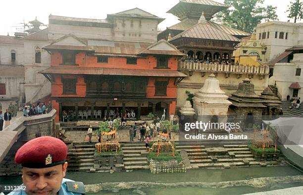 Policeman keeps an eye on the crowd as mourners gather to witness the cremation ceremony of the Nepalese royal family at Pashupati Nath Arya Ghhat,...