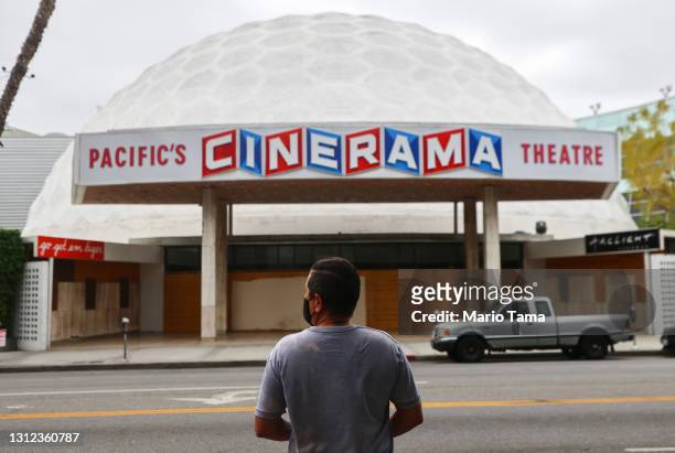 Person stands while taking photos of the famed Cinerama Dome at the shuttered ArcLight Hollywood movie theater on April 13, 2021 in Los Angeles,...